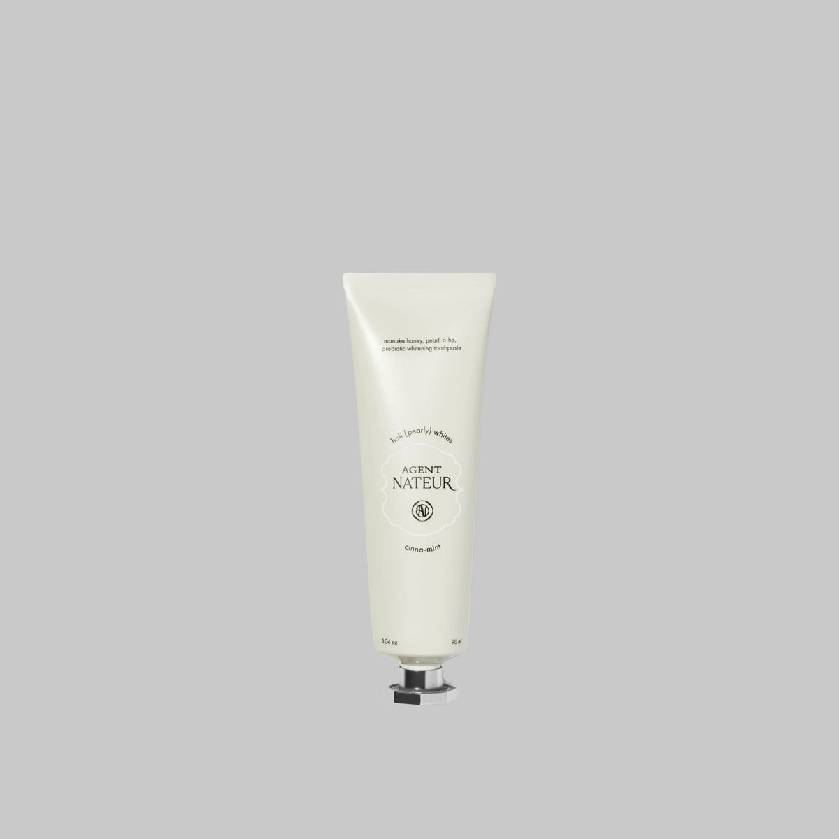 Agent Nateur holi (pearly) whites probiotic whitening toothpaste tube on a gray background