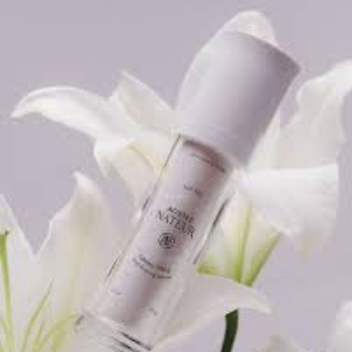 Agent Nateur Holi (Lift) serum bottle nestled among white lilies.