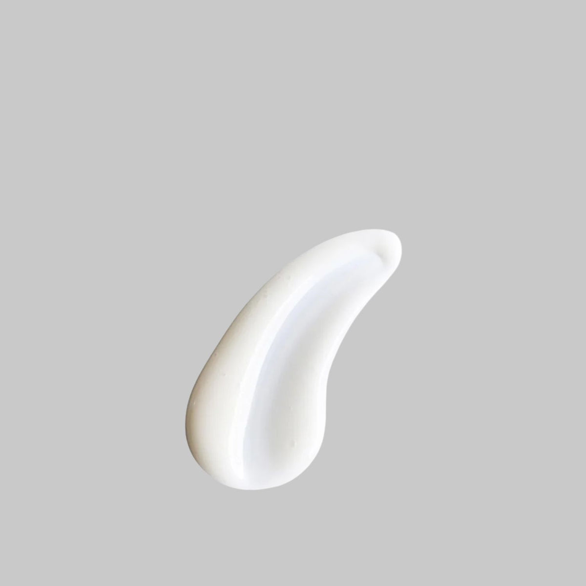 White, creamy swatch of Bloomeffects Royal Tulip Dew Drops serum on a gray background.