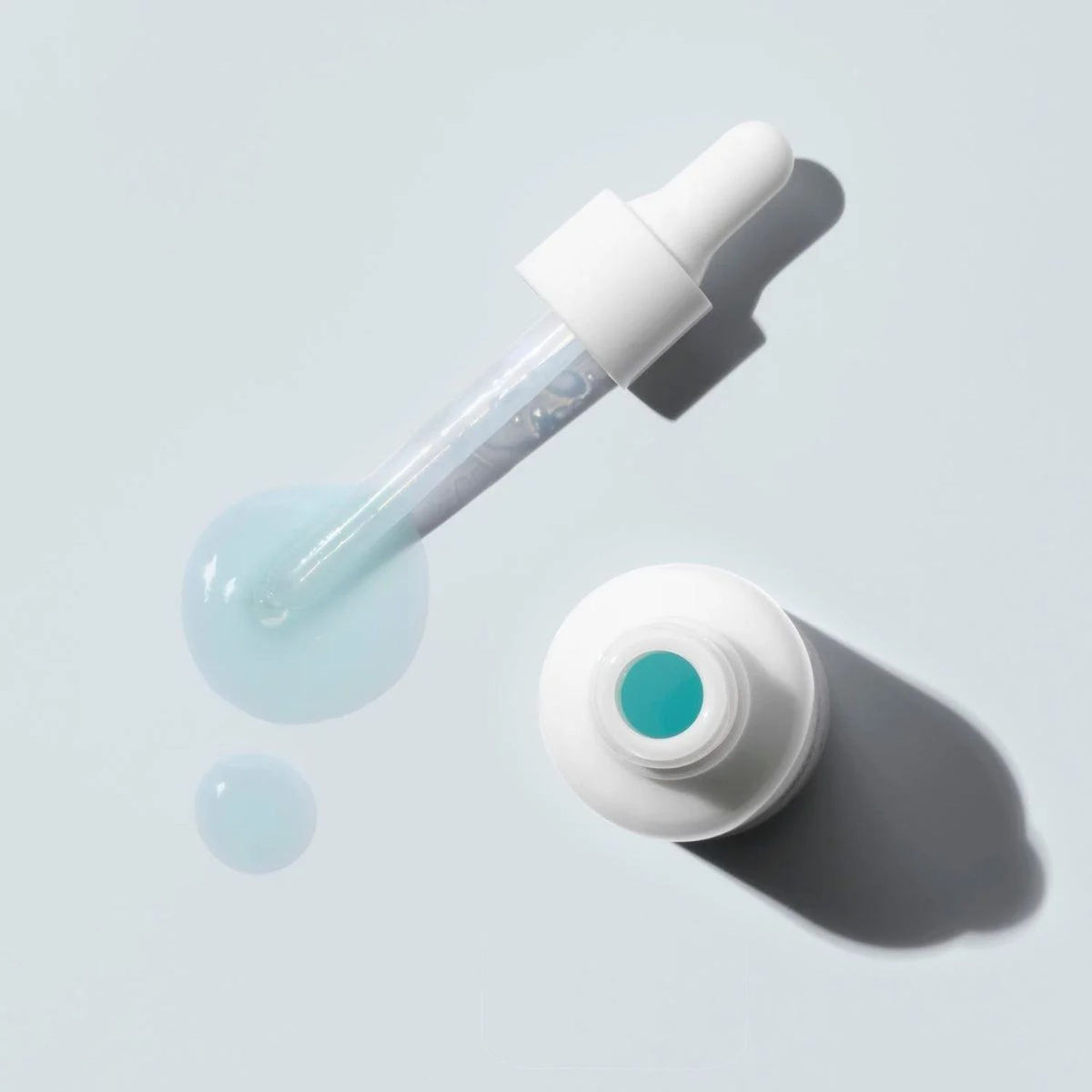 Ere Perez White Tea Phyto-Retinol Elixir with an open bottle, glass dropper and pale blue serum.