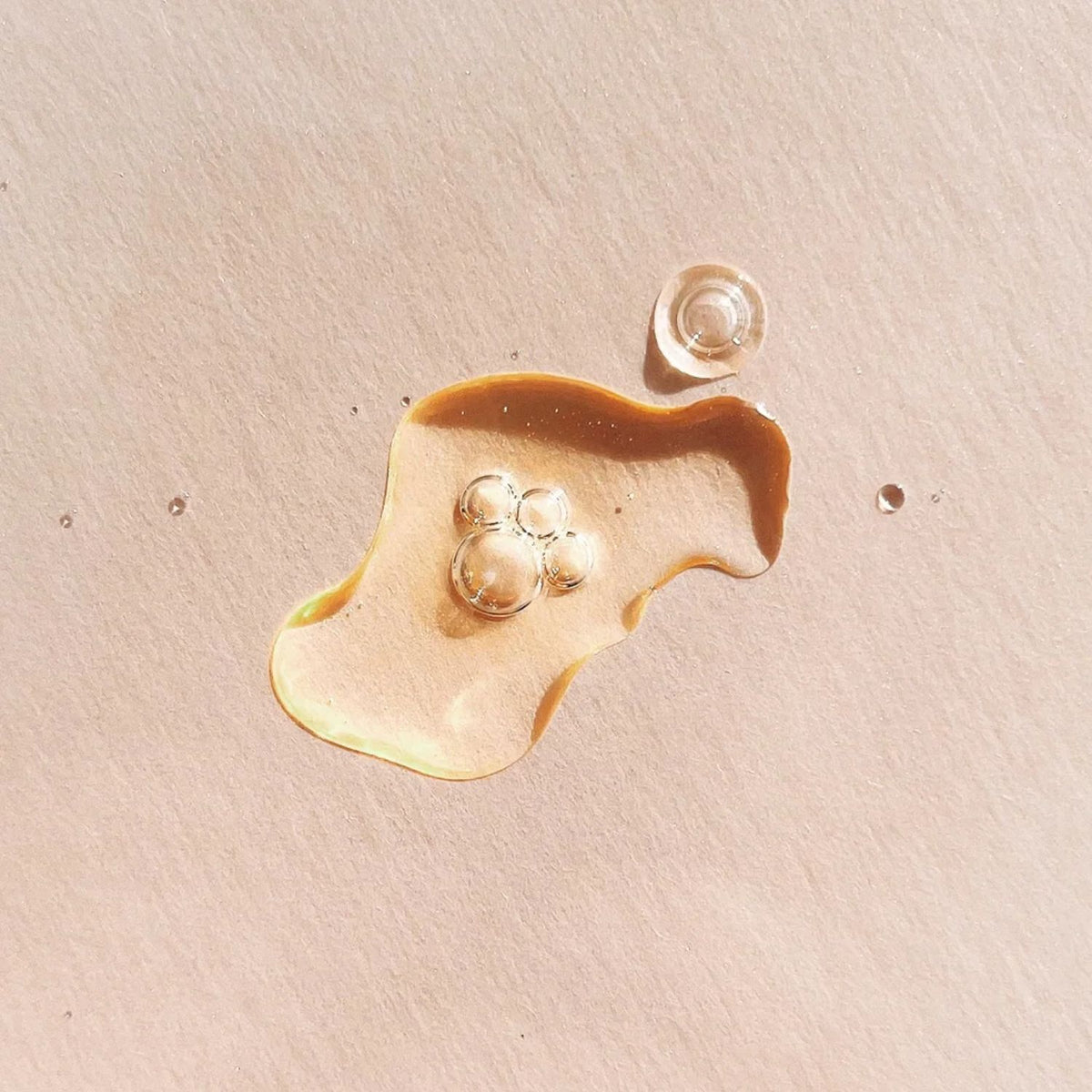 TAHNYC C Radiance Nurture vitamin C serum with bubbles on a pale pink surface.
