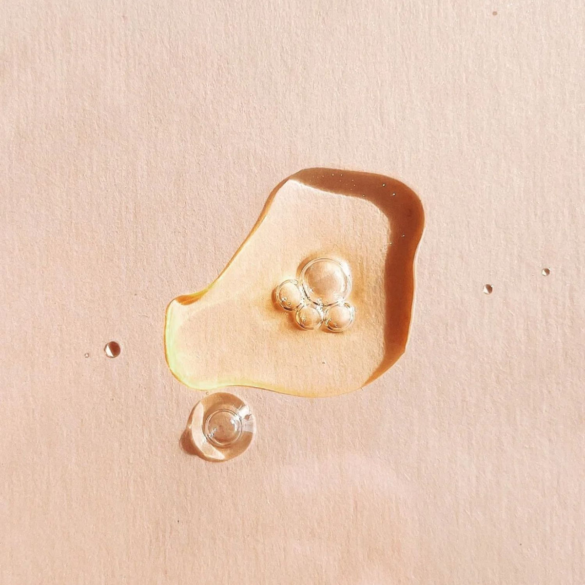 Golden TAHNYC Noir Perfecting retinol serum with small bubbles on a peach background