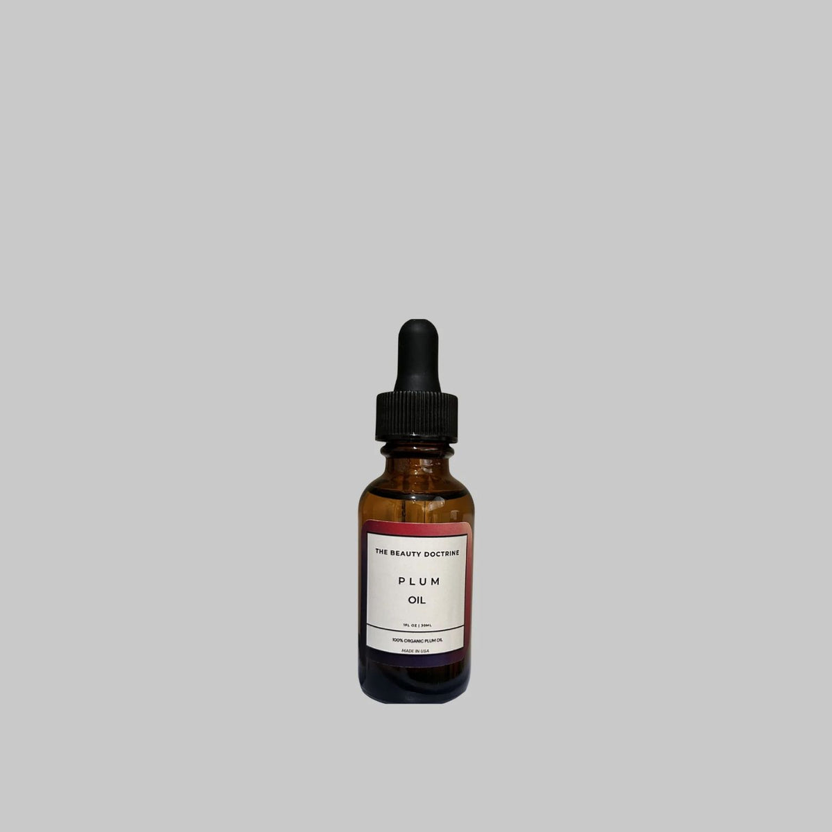 The Beauty Doctrine organic plum oil, 30 ml, in an amber glass bottle with a black dropper.